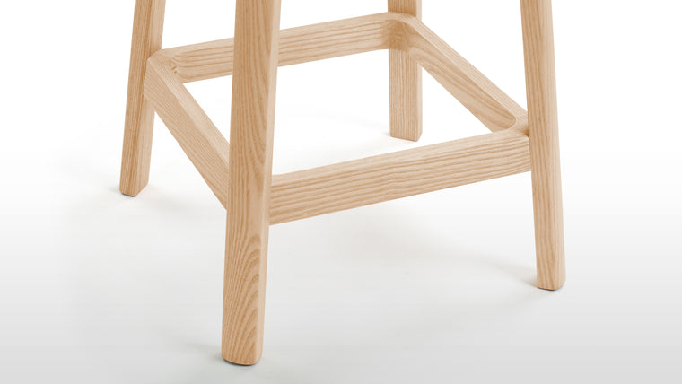 Timeless Design | The stool's solid wood frame boasts clean lines and a rich finish that perfectly complements the rattan seat. The angled legs provide stability while adding a hint of architectural interest to the overall aesthetic.
