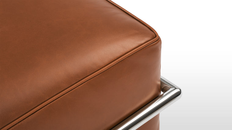 SLEEK FRAME | The Corbusier Ottoman boasts a sturdy and sleek stainless steel frame, which not only provides exceptional stability but also complements the leather upholstery with its polished, minimalist aesthetic. The iconic tubular frame design is instantly recognizable and adds a touch of architectural elegance to your space.

