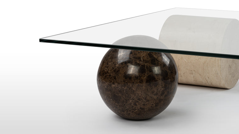 Scupltural Design | The Solange Coffee Table is a true work of art, designed to spark conversation and ignite the imagination. Its unconventional shape creates a sense of movement and dynamism. Crafted with meticulous attention to detail, the table boasts a combination of materials, including glass, marble, and travertine, that exude a harmonious juxtaposition of strength and transparency.
