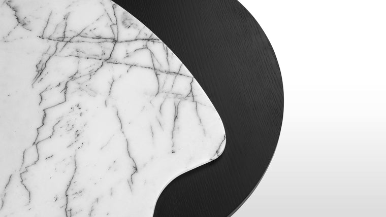 Monochrome Contrast | Crafted with stunning Calacatta marble and an oak veneer, this table highlights high-quality materials. The matte black finish contrasts beautifully with the white marble background, and emphasizes the dark veining, highlighting the one-of-a-kind nature of each table.
