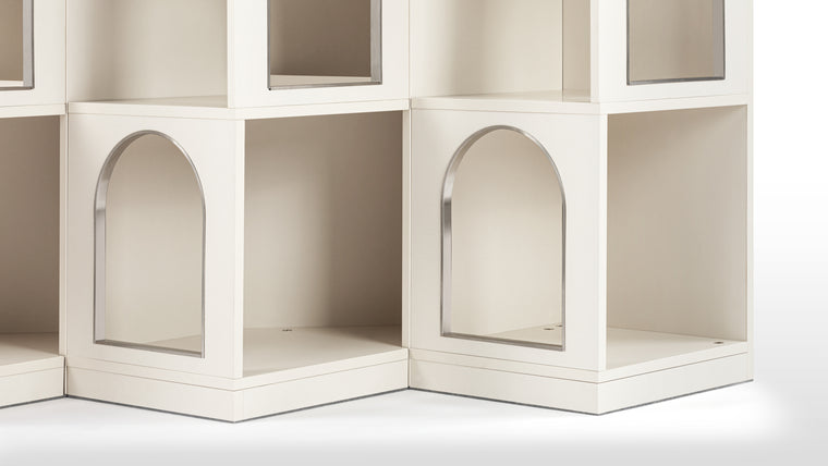 Dynamic Display | Pockets of organized storage for whatever you wish to store but not hide away. The bookshelf artfully obscures and showcases through its mix of arched and square windows, opening into recessed spaces.
