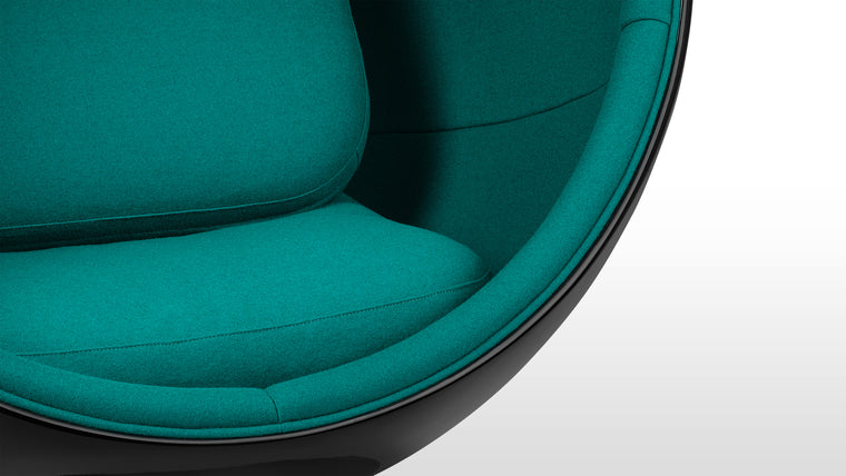 Color Contrast|Inside its black half-sphere, this unique chair features vibrant upholstery for a beautiful pop of color.
