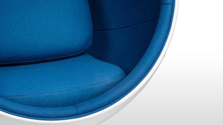 Color Contrast|Inside its white half-sphere, this unique chair features vibrant upholstery for a beautiful pop of color.
