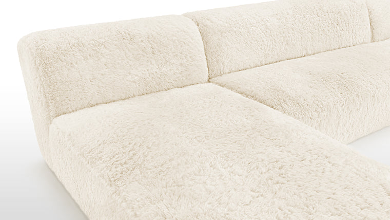 Material Harmony | Crafted with meticulous attention to detail, the Iona Sectional is upholstered in faux sheepskin, a soft and sumptuous material that not only feels luxurious but also radiates an inviting warmth. Its light cream tone adds an air of sophistication and minimalism, blending seamlessly with diverse décor styles.
