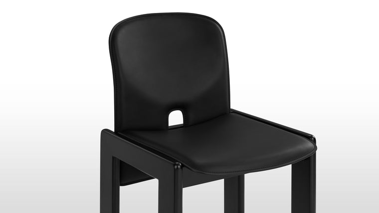 Striking in Black | The Boli Chair boasts a sophisticated all-black design, upholstered in smooth black leather with a matching black-painted base. Its minimalist form, clean lines, and unique backrest cutout make it a modern design statement.
