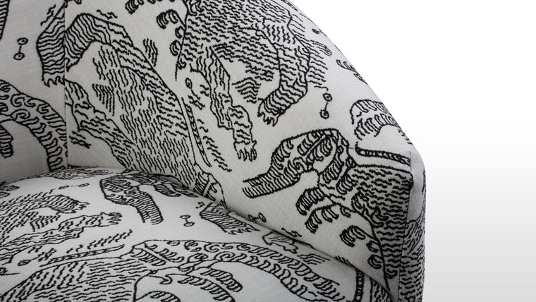 Vivid Design | Crafted with a sharp geometric frame, the chair is upholstered with soft fabric adorned with dynamic tiger motifs in black ink on a crisp white backdrop. The contrast and movement of the patterns lend a vivid, artistic touch.
