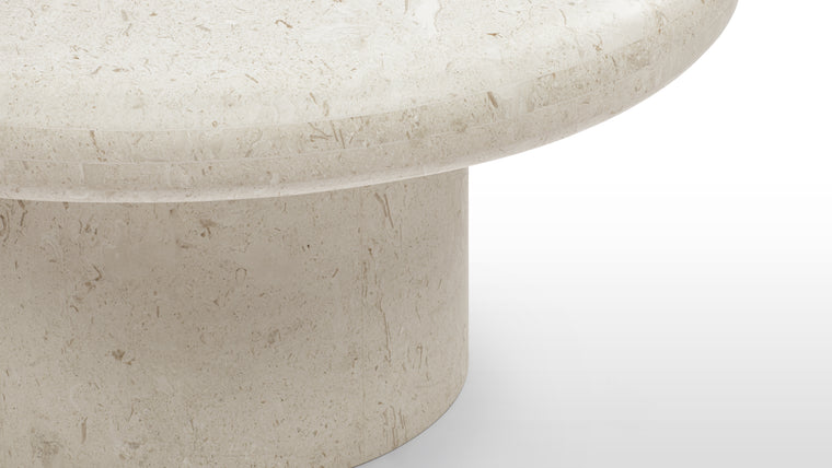 Elegant Simplicity | Crafted from warm limestone, the Valencia Coffee Table embodies a minimalist aesthetic with its rounded edges and pillar base. Its natural tones and sleek lines exude understated elegance.
