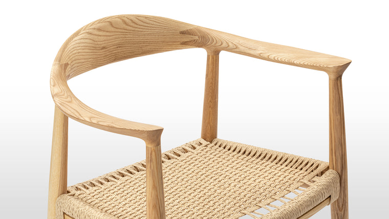 Beauty in the Details | The quality of the The Round Chair can be seen in its refined details. From the gentle splay of the back legs to the tapered arm rests, every aspect of the design is finessed. Made from solid Ash with a hand-woven paper cord seat, this chair is made to last; buy for yourself, and hand down to future generations.
